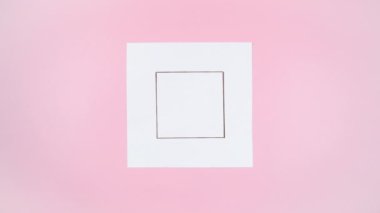 Kırmızı kurdeleyle bağlanmış el sanatları kağıdının 4K çizimi beyaz kağıt parçasında görünür. O zaman boyalı olanın yerine gerçek hediyeyi eller alır. Açık pembe arka plan. Uzayı kopyala Hareketi durdur.