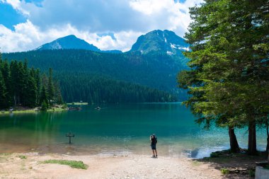 Zabljak, Karadağ - Durmitor 'da Med Peak ile birlikte Kara Göl yakınlarındaki Man turisti. Yürüme yolu gölün etrafında dönüyor ve dinlenme ve yürüyüş için popüler bir yer..