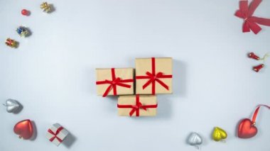 4k 3 kutu el işi kağıdına sarılı ve kırmızı kurdeleyle bağlanmış. Tatil ve hediye hazırlığı kavramı. Açık gri arkaplan. Düz yatıyordu. Uzayı kopyala Hareketi durdur.