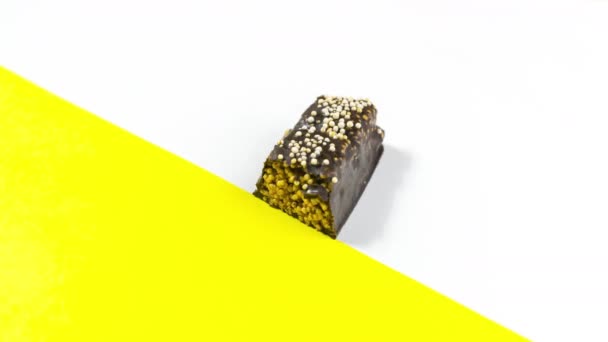 4K在带有黄色口音的白色背景上 一个长方形巧克力糖果在被吃掉时出现并逐渐消失 甜食概念 停止动作动画 复制空间 平躺在床上 — 图库视频影像