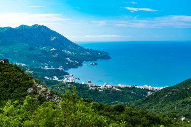 Budva Riviera 'nın tepesinden bak. Sveti Stefan 'dan Karadağ' daki Adriyatik Denizi üzerindeki Becici şehrine kadar olan kıyı şeridi. Mavi gökyüzüne karşı yeşil dağların güzel manzarası.