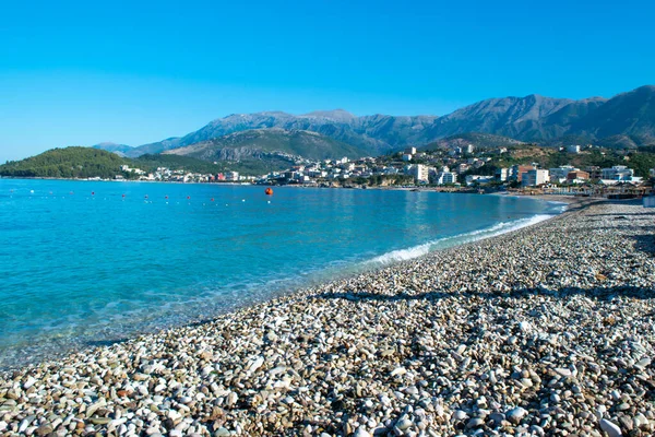Himare 'nin dağların eteğindeki güzel çakıl taşı plajı. Adriyatik Denizi. Arnavutluk. Yaz bulutu manzarası. Yaz tatili ve rahatlama kavramı.