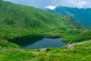 Capra Gölü, Transfagarasan dağ yolu yakınlarındaki Fagaras Dağları 'nda bulunan buzul gölüdür ve dünyanın en güzel yollarından biridir. Karpatlar. Romanya.