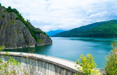 Transfagarasan yolu, Romanya - 23 Haziran 202: Vidraru barajından geçen turistler. Vidraru Gölü 'nün üst manzarası. Transfagarasan yolu, dünyanın en güzel yollarından biridir. Karpatlar. Romanya.