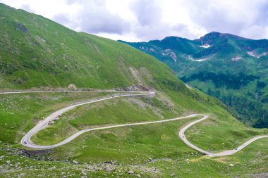 Serpentine Transfagarasan yolunda keskin virajlardaki arabalar dünyanın en güzel yollarından biridir. Yeşil dağ yamaçları. Karpatlar. Romanya.