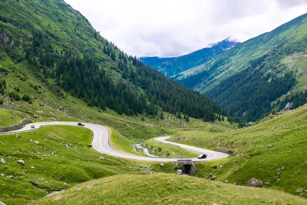 サーペンタインTransfogarasan道路の鋭利なターンで車は 世界で最も美しい道路の一つです 緑の山の斜面の丘 カルパチア人 ルーマニア — ストック写真