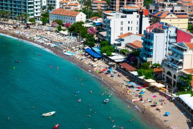 Dağın eteklerinde yer alan Becici ve Rafailovici tatil köylerinin panoraması. Karadağ. Adriyatik Denizi. Yaz güneşli bir gün. Deniz kenarı tatil kavramı.