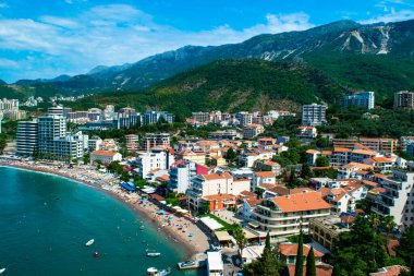 Dağın eteklerinde yer alan Becici ve Rafailovici tatil köylerinin panoraması. Karadağ. Adriyatik Denizi. Yaz güneşli bir gün. Deniz kenarı tatil kavramı.