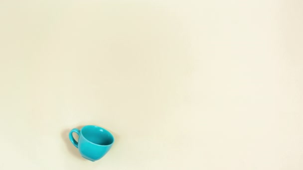 4K美丽的林登花的艺术组成从蓝色的杯子溢出 天然花卉和草本茶的概念 米色背景 停止动作动画 平躺在床上 — 图库视频影像
