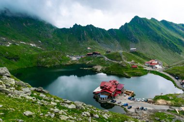 Balea Gölü kıyısındaki Chalets Fagaras Dağları 'ndaki buzul gölüdür. Transfagarasan dağ yolu, dünyanın en güzel yollarından biridir. Güzel dağların manzarası. Karpatlar. Romanya.