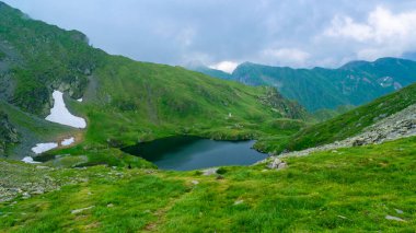 Capra Gölü, Transfagarasan dağ yolu yakınlarındaki Fagaras Dağları 'nda bulunan buzul gölüdür ve dünyanın en güzel yollarından biridir. Karpatlar. Romanya.