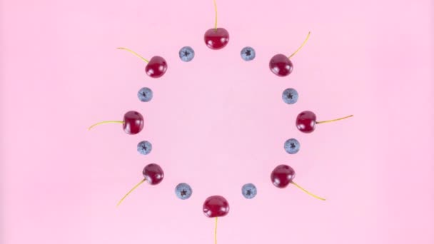 Berries Cherries Blueberries Arranged Circle Converge Alternately Center Pink Background — Stok Video