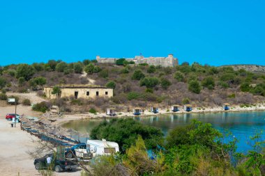 Beach and old fortress Ali Pasha Tepelena Fortress Porto Palermo near Himare city located on a peninsula in the bay of the Ionian Sea. Albania. Blue summer landscape.