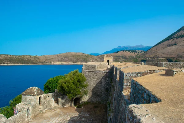 Walls of an old fortress Ali Pasha Tepelena Fortress Porto Palermo near Himare city located on a peninsula in the bay of the Ionian Sea. Albania. Blue summer landscape.