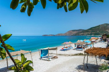 Borsh Beach, Albania - July 14, 202: Vacationers on long beach with clear blue water. Cloudless sky. Ionian Sea. Summer landscape. Concept of summer holidays and relaxation.