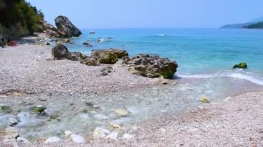 Dağ nehrinin berrak suları İyon Denizi 'ne, Potam Sahili' ne akar. Himare kasabası. Arnavutluk. Yaz bulutu manzarası.