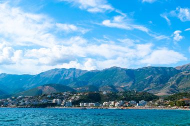 Himare sahil kasabasının güzel yaz bulutları İyon ve Adriyatik denizlerinin sınırındaki dağların eteklerinde. Arnavutluk. Yaz tatili ve rahatlama kavramı.