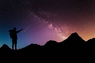 Gece vakti uzun süre manzara fotoğrafçılığı. Yüksek bir yerde duran gezgin Samanyolu 'na hayret içinde bakıyor.