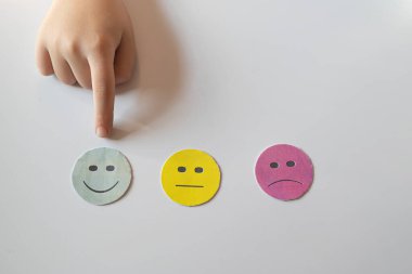 Çocuk, beyaz arka planda mutlu bir gülümseme seçiyor. Değerlendirme ve değerlendirme konsepti. Müşteri hizmetleri tecrübesi ve memnuniyet araştırması.