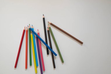 Beyaz arka planda boya kalemleri ve dört çocuk eli. Eðitim kavramı. Pandemik dönem boyunca çocuk eðitimi kavramı.