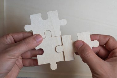 Eller bulmaca parçalarını birbirine bağlıyor. Eller bulmaca parçalarını birbirine bağlıyor. Seçici odaklanma..