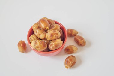 Kırmızı kasede beyaz arka planda tarihler. Üst görünüm. Ramazan kavramı. Seçici odak makro görüntüsü.