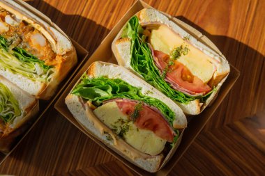 Salatalı, domatesli ve yumurtalı sandviçin üst görüntüsü.