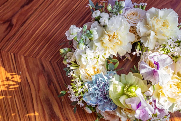 Deniz şakayığı ve karanfil de dahil olmak üzere gün ışığı altında çiçek buketi veya çelenk.