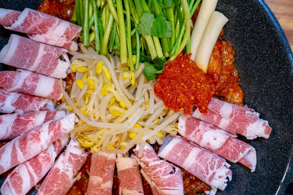 Kore usulü bebek ahtapot biftek ve fasulye filizi ile kızartır, Kore baharatlı yemekleri, yemek pişirmeden önce bir restoranda alınır.