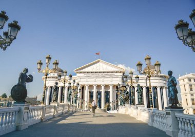 ÜSKÜP, Kuzey MACEDONYA-AĞUSTOS 23 Ağustos 2019: Makedonya Arkeoloji Müzesi 'ne giden köprüyü yürüyerek geçen adam.