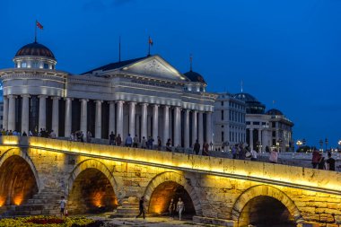 ÜSKÜP / NORTH MACEDONIA-AĞUSTOS 28 2018: İnsanlar Taş Köprü 'yü akşam geçerek Eski Pazar ve Makedonya Meydanı' na gidiyorlar.
