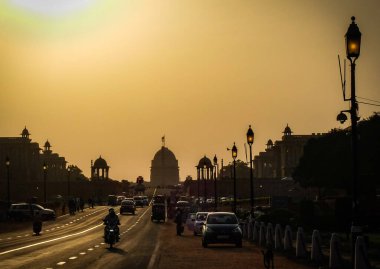 Öğleden sonra Rajpath 'de Hindistan başkanlarının resmi binalarına ve devlet dairelerine giden trafik bir aşağı bir yukarı gider..