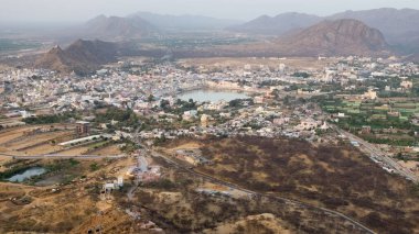 Uzun patika, Hindular için popüler bir hac alanı olan Ratnagiri Tepesi 'nde bulunan tapınaktan inerken, uzaklarda görülen çekici küçük kasaba..