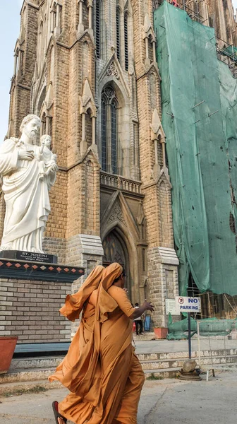 インドのカトリック修道女たちは 聖フィロメナ教会の外に祝福された聖母マリアの配偶者であるヨセフの像を過ぎて急いでいます — ストック写真