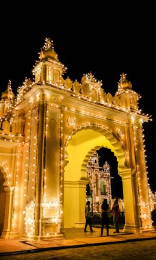 MYSURU (MYSORE), KARNATAKA / INDIA-FEBUARY 11 2018: Mysore Palace 'ın tapınağı ve kapıları aydınlanıyor, alacakaranlıktan kısa bir süre sonra binlerce ampul kaplanıyor.