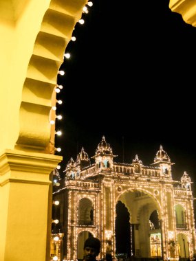 MYSURU (MYSORE), KARNATAKA / INDIA-FEBUARY 11 2018: Mysore Palace 'ın tapınağı ve kapıları aydınlanıyor, alacakaranlıktan kısa bir süre sonra binlerce ampul kaplanıyor.