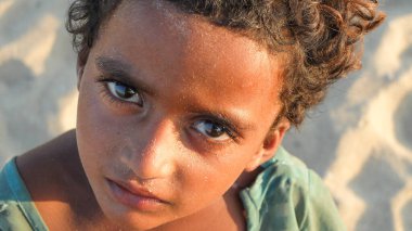 CHENNAI, TAMIL NADU / INDIA-MARCH 2. 2018: Genç bir kız çocuğu Marina sahilinin kumları boyunca para dileniyor.