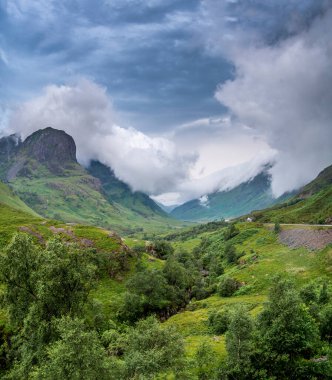 Early evening post sunset clouds roll in quickly, along the beautiful green valley,during the summer,a distant white cottage within the dramatic landscape,causing ever changing lighting conditions.