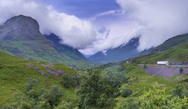 Early evening post sunset clouds roll in quickly, the main road passes along the beautiful green valley of Glencoe,during the summer the landscape is covered with lush grass.