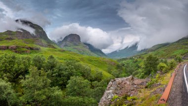 Next to the A82 road, cloud quickly rolis in,along the beautiful green valley of Glen Coe,clinging to the mountains,in mid-summer,causing ever changing light,typical of the Highlands of Scotland.