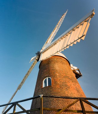 WILTON, WILTSHIRE / ENGLAND-AĞUSTOS 08 2020: 17. yüzyılın yenilenmiş yel değirmeni, gönüllüler tarafından sevgiyle bakılıyor ve hala un üretiliyor, barışçıl kırsal kesimde şafakta ayakta duruyor.