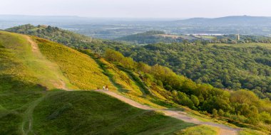 Doğudaki anıt, bir yaz sabahı, yemyeşil, yemyeşil bir manzaranın arasında, Malvernlerin doğal güzelliği ve tepelerin miras aralığından, erken altın güneş ışığında açıkça görüldü..