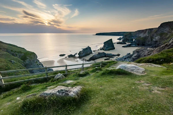 Bedruthan Steps tourist and beauty spot,a stretch of National Trust coastline on the north Cornish coast near Padstow and Newquay,in mid summer,with calm,fair weather Atlantic Ocean waters beyond.