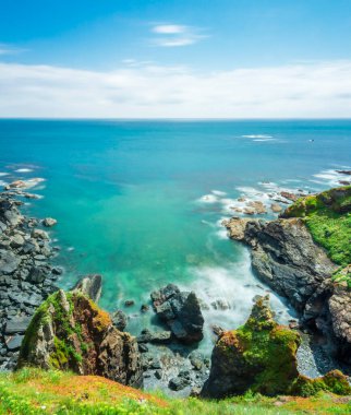 Güzel, açık, güneşli yaz havası, çimen çiçekli uçurumlar, sakin denizler, dramatik kıyı şeridi, İngiliz anakarasının en güney noktası. Kertenkele Köyü yakınlarında popüler bir turizm beldesi..