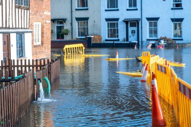 Bewdley, Worcestershire, İngiltere, UK- 22 Şubat 2022: Yakındaki Severn nehrinden gelen su baskını suları evlerden dışarı pompalanarak trafiğe kapatılmış sel basmış yollara dökülmeli.