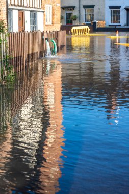Bewdley, Worcestershire, İngiltere, UK- 22 Şubat 2022: Yakındaki Severn nehrinden gelen su baskını suları evlerden dışarı pompalanarak trafiğe kapatılmış sel basmış yollara dökülmeli.
