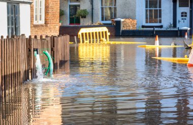 Bewdley, Worcestershire, İngiltere, UK- 22 Şubat 2022: Yakındaki Severn nehrinden gelen su baskını suları evlerden dışarı pompalanarak trafiğe kapatılmış sel basmış yollara dökülmeli.