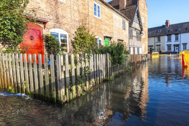 Bewdley, Worcestershire, İngiltere, UK- 22 Şubat 2022: Severn nehrinin kıyısındaki bir kulübeden suyu boşaltmaya çalışan bir yerleşimci ve daha fazla sel bekleniyor..