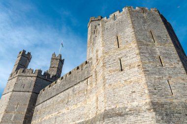 Orta Çağ 'ın en büyük binalarından biri olan Galler bayrağı gökyüzünde dalgalanıyor. Büyük bir yapı, dramatik bir sanat eseri. Çokgen kuleler, kartal heykelleri ve çok renkli duvarlar..