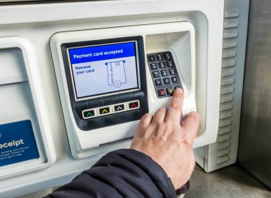 Kidderminster, Worcestershire, İngiltere, ABD - 7 Nisan 2022: Tesco dolum istasyonu müşterisi benzin pompasını kullanmadan önce yakıt parasını bankamatik kartıyla ödüyor.